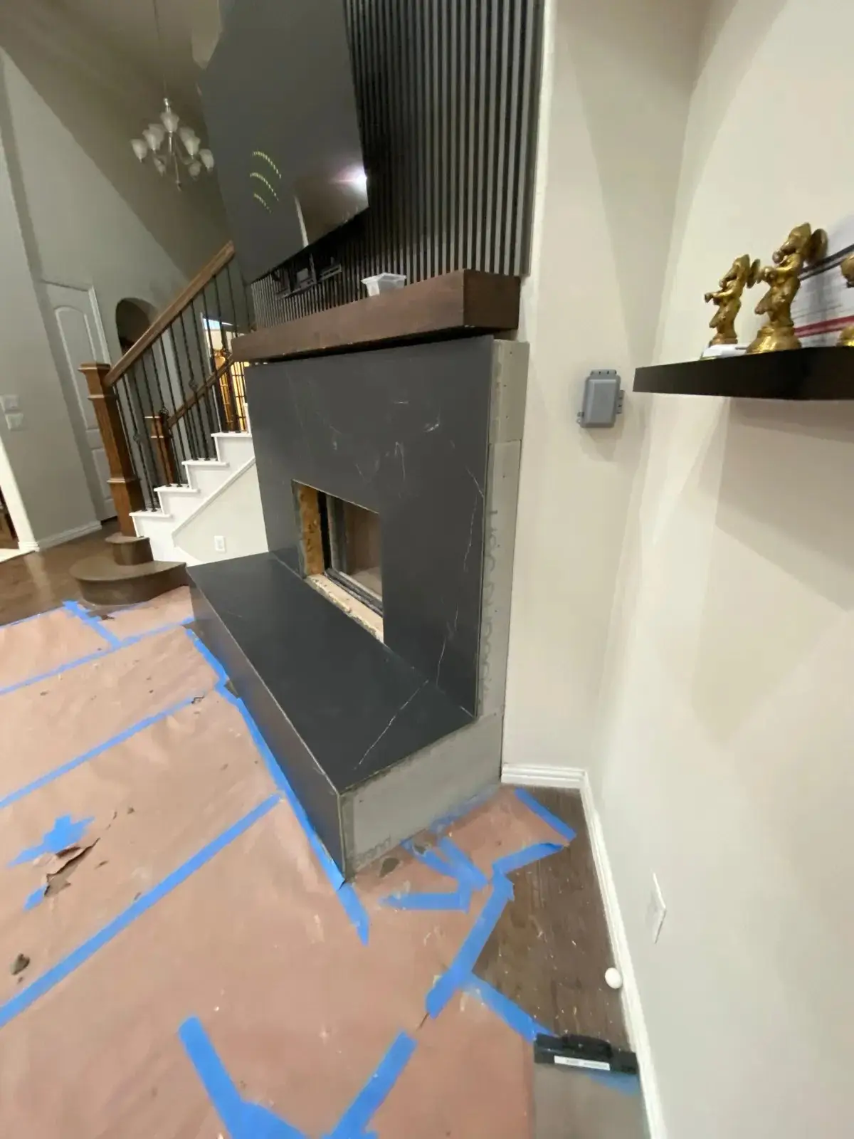 Fireplace installation in progress with floors protected