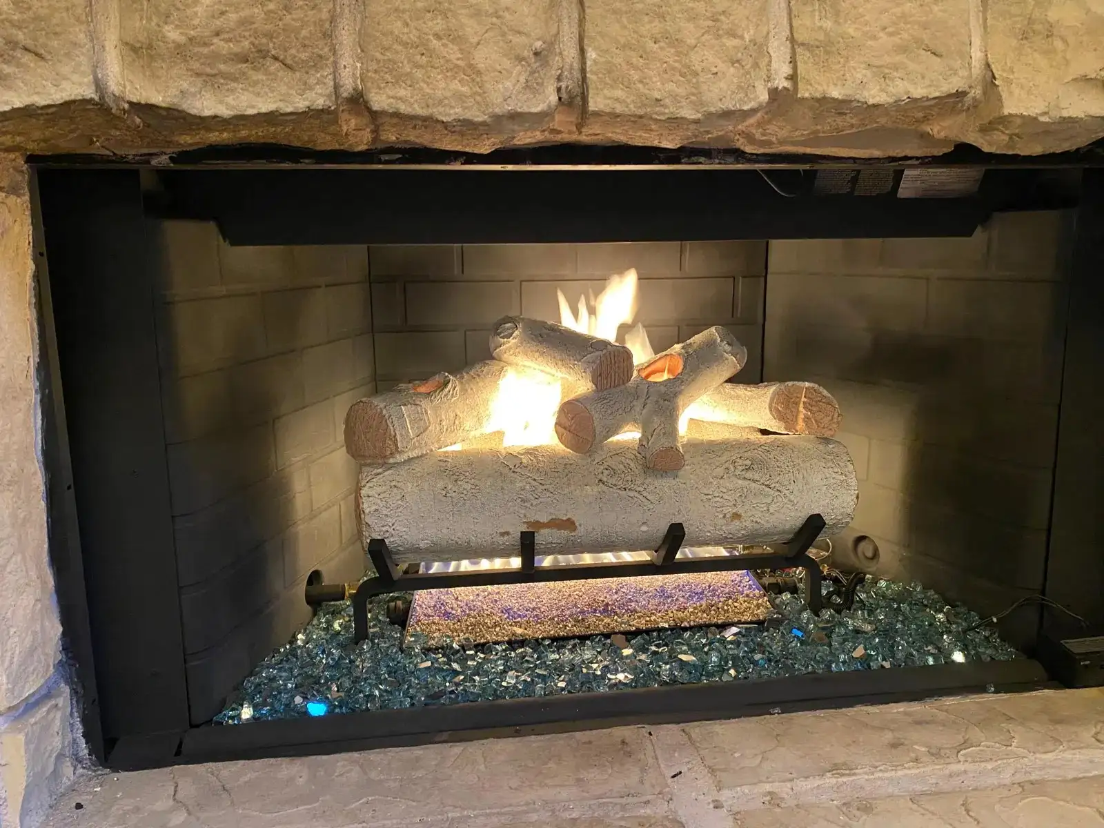 Gas log set installed and lit in a fireplace